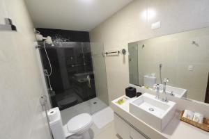 a bathroom with a toilet and a sink and a shower at Suites Tropical in João Pessoa +56 photos