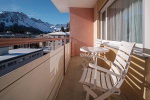 un balcon avec deux chaises et une table sur un balcon dans l'établissement Paradies 606, à Arosa