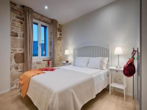 a bedroom with a white bed and a brick wall at Stylish Holiday Home Vis Center in Vis