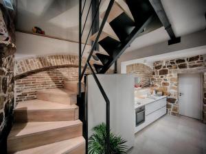 a kitchen with a staircase and a brick wall at Stylish Holiday Home Vis Center in Vis