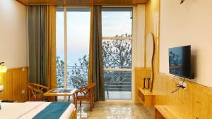 a hotel room with a bed and a large window at New Heights Kasauli by Humble Stya in Kasauli