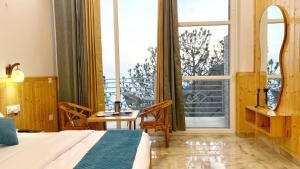 a bedroom with a bed and a table and a large window at New Heights Kasauli by Humble Stya in Kasauli +21 photos