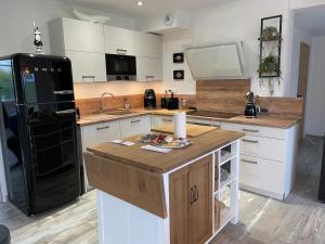a kitchen with white cabinets and a black refrigerator at Villa 800 in Wissant