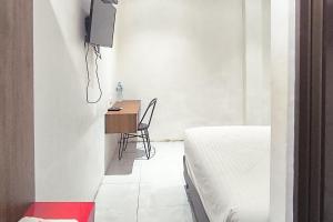a small bedroom with a desk and a bed at Urbanview Hotel Anata Inn in Pamanjengang