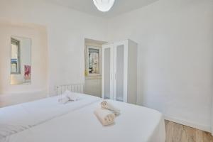 a white bedroom with two beds with towels on them at Casa De Esme ll in Haro