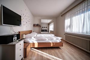a bedroom with two beds and a flat screen tv at Paradies 212 in Arosa