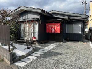 富士河口湖折々祭ー河口湖駅徒歩六分富士山ビューとホームシアター庭付的门上带有红色标志的黑色房子