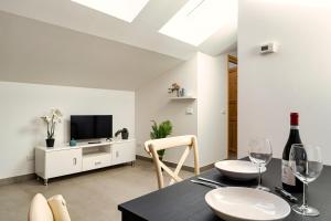 una sala da pranzo con tavolo e bicchieri da vino di Residence La Corte - Mansarda 8 a Novara