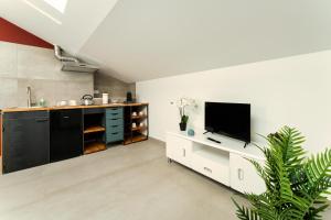 una cucina con TV a schermo piatto e mobile bianco di Residence La Corte - Mansarda 8 a Novara