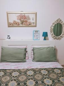 a bedroom with a bed with a mirror on the wall at La Perla B & B in Ciampino