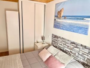 a bedroom with a bed and a picture of the ocean at El Botón del Charro Cudillero Casco viejo in Cudillero