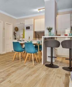a kitchen with blue chairs and a table in a room at Coral Apartment La Cala Beach in La Cala de Mijas