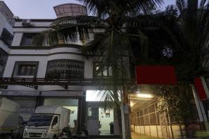 a palm tree in front of a building with a truck at Super Townhouse The Upper Room Near Pune Airport in Pune