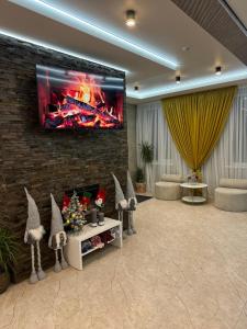 a living room with a fireplace and a tv on a brick wall at Guest House Zatyshnyi Dvir in Bukovel +208 photos