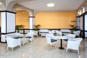 a restaurant with white chairs and tables at Aparthotel Los Dragos del Sur in Puerto de Santiago