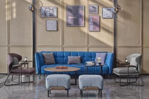 a blue couch in a room with a table and chairs at Four Points by Sheraton Datong Pingcheng in Datong