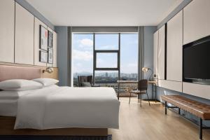 a bedroom with a white bed and a large window at Four Points by Sheraton Datong Pingcheng in Datong