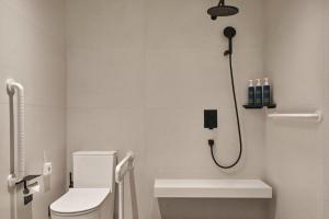 a bathroom with a shower with a toilet and a sink at Four Points by Sheraton Datong Pingcheng in Datong