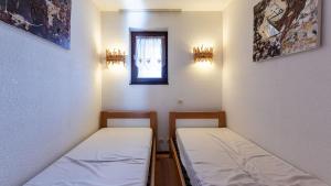 two beds in a small room with a window at Grand Morillon 212 - 2P5 in Morillon