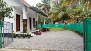 a house with a gate and a fence at Heaven Residency in Munroe Island