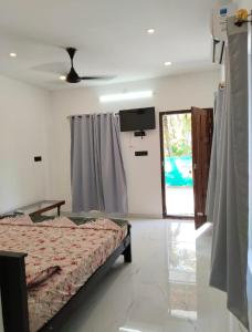 a bedroom with a bed and a tv and a window at Heaven Residency in Munroe Island +7 photos