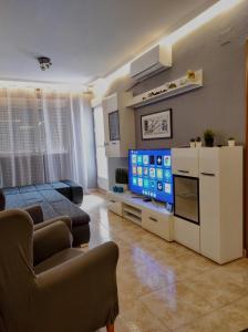 a living room with a couch and a tv at Parque De Las Naciones Dragon con garaje ! in Torrevieja