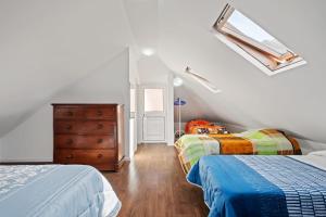 a bedroom with two beds and a dresser and a window at Casa da Avó Paraíso in Machico
