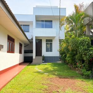 a house with a lawn in front of it at Coastal Cloud in Hikkaduwa