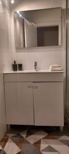 Un baño blanco con lavabo y espejo. en Quinta de Loubite, en Lagoa