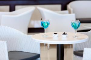 two wine glasses on a table with blue drinks at Aparthotel Los Dragos del Sur in Puerto de Santiago