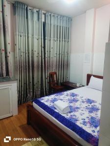 a bedroom with a bed and a window with curtains at Hotel Phương Linh 360 phạm hùng in Ho Chi Minh City