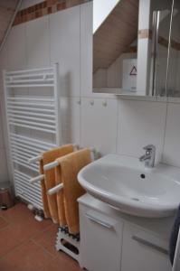 a bathroom with a sink and a mirror and towels at Ferienhaus Strandläufer in Krummhörn +7 photos
