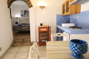a kitchen with a counter and a table with chairs at Bouganville- Le casette di Marilena in Pantelleria