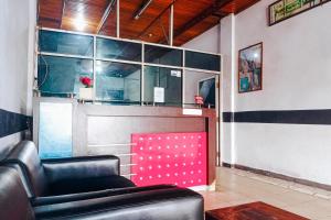 a waiting room with a leather chair and a counter at RedDoorz at Hotel Island Bengkulu in Bengkulu