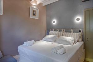 a bedroom with a white bed with towels on it at Sunset & Ocean view Villa in Patmos