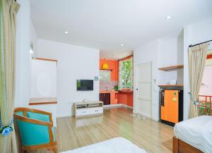 a living room with an orange and white kitchen at Baan Sarika Phusuan in Nakhon Nayok