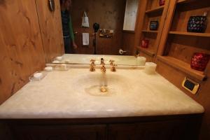 a bathroom with a sink and a man in the mirror at Chalet Ampezzano di Marisa in Cortina dʼAmpezzo +15 photos
