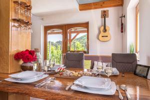 a table with plates and glasses and a guitar at Holiday home in Trebnje Kranjska Krain 42897 in Trebnje +40 photos