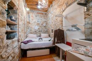 a small room with a bed in a brick wall at Almond Blossom Cottage 1 in Philotium