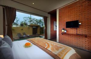 a bedroom with a bed and a large window at Kanaka Villas by Prabha in Tampaksiring