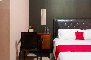 a bedroom with a bed and a chair and a desk at RedDoorz at Hotel Island Bengkulu in Bengkulu