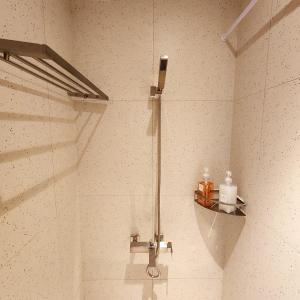 una doccia in un bagno con una porta in vetro di Canvas Hostel a Busan