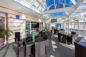 a restaurant with tables and chairs and windows at Aparthotel Los Dragos del Sur in Puerto de Santiago