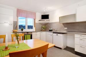 a kitchen with white cabinets and a wooden table at Wohnung beim Obsthof in Meckenbeuren +16 photos