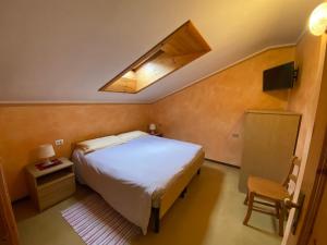 sypialnia z dużym łóżkiem i oknem dachowym w obiekcie Hotel Eira w mieście Bormio