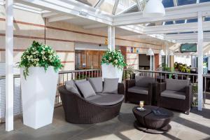 a lobby with two chairs and flowers on a balcony at Aparthotel Los Dragos del Sur in Puerto de Santiago
