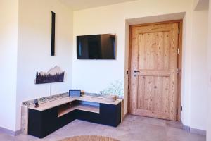Habitación con escritorio, TV y puerta. en Bellagio - Baita treeb Tivano, en Bellagio