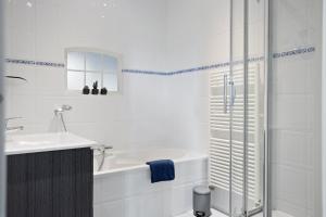 a white bathroom with a tub and a sink at Boerderij de Borgh in Westerbork +65 photos