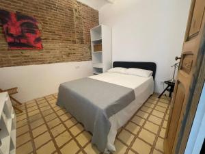 Un dormitorio con una cama y una pared de ladrillo. en Barcelona Besos Apartment 15' to Plaza Cataluña, en Sant Adrià de Besòs