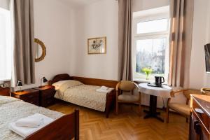 pokój z dwoma łóżkami, stołem i oknem w obiekcie Hotel Europa w Polanicy Zdroju